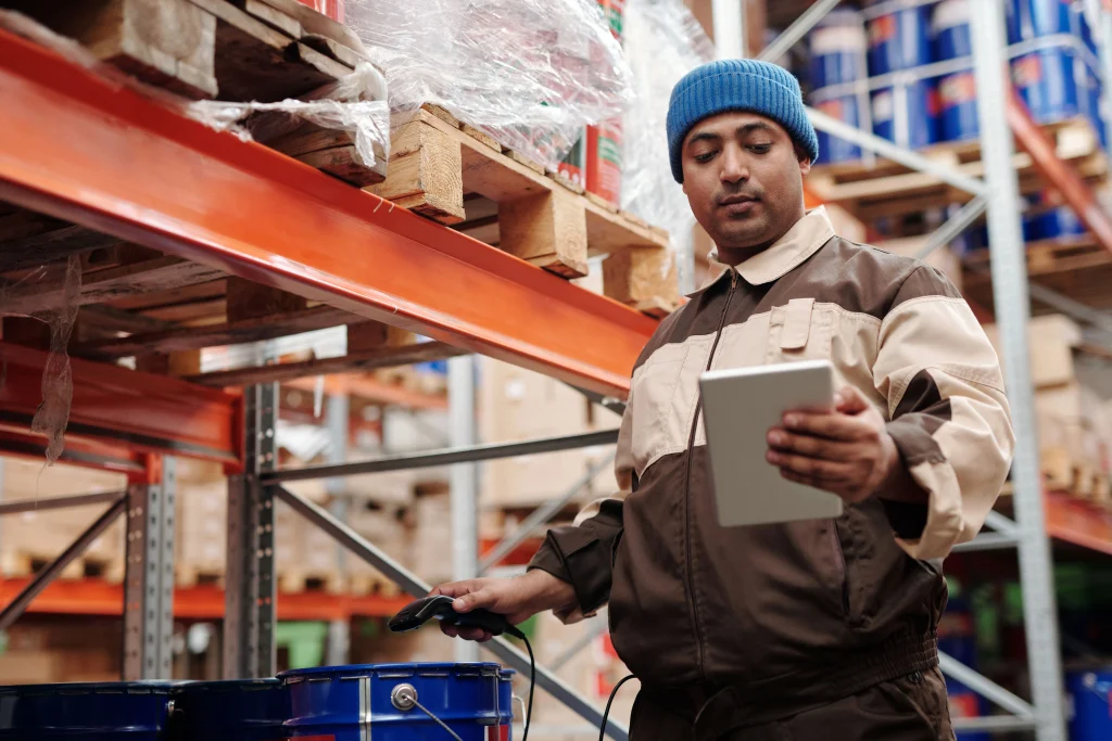 Why Businesses Are Moving From Sage 200 To Microsoft Dynamics 365 Business Central Warehouse Worker Using A Tablet To Check Stock And Manage Manufacturing Inventory