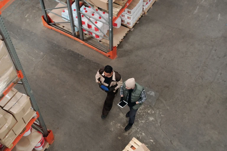 Warehouse Staff Checking Stock Levels On A Tablet Two Workers In A Warehouse Checking Inventory Together On A Digital Tablet